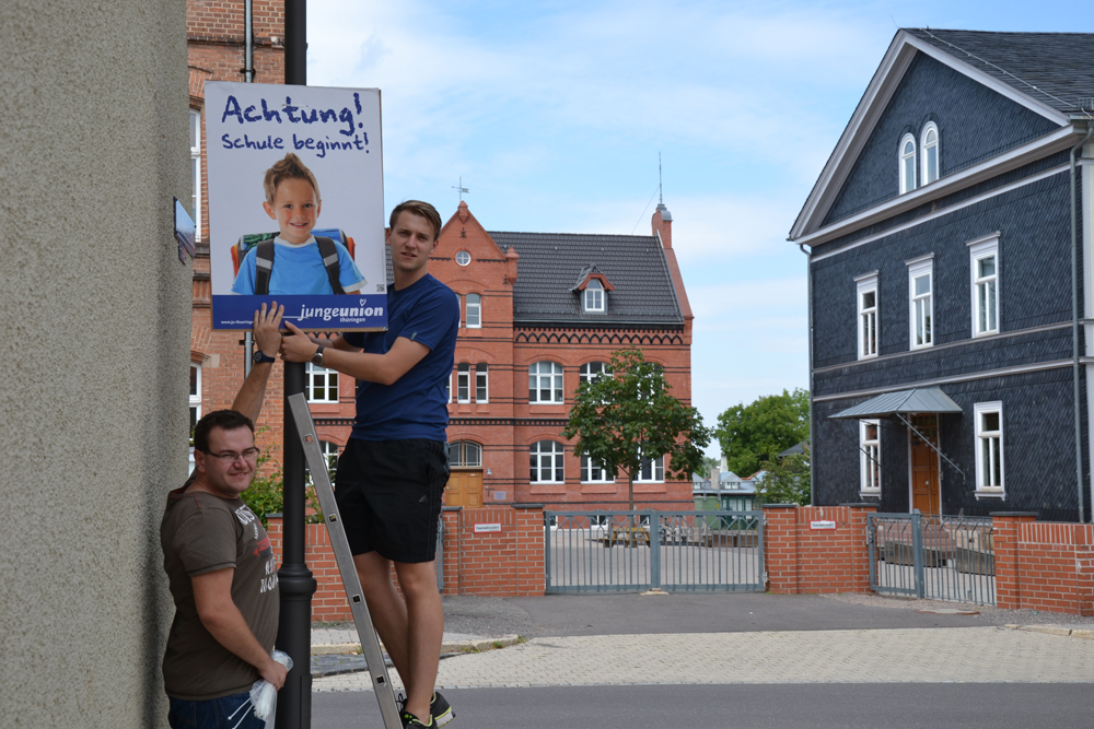 Junge Union Kreischef Felix Elflein und sein Stellvertreter Michael Mempel in Waltershausen beim Anbringen eines Hinweisplakates